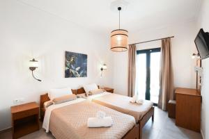 a bedroom with two beds with white towels on them at Aspri Petra Apartments in Hersonissos