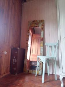 uma cadeira branca e uma porta num quarto em Cabaña del Zapatero El Bierzo Ponferrada em Valdecañada