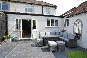 a patio with a couch and a table and chairs at Central Townhouse with FREE onsite EV parking in Stratford-upon-Avon