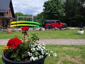 a planter with flowers and a boat in a yard at Hubertówka in Somonino