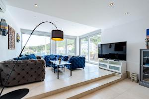 a living room with a couch and a tv at Suartini Apartmani Račišće in Račišće
