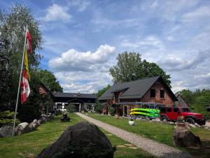 a house with a flag and a truck in front of it at Hubertówka in Somonino