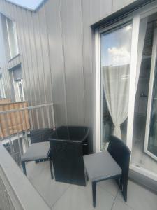balcón con sillas, mesa y ventana en Lovely apartment Nadolnik, en Poznan