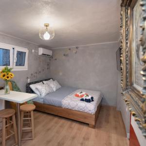 Cozy tiny apartment in the heart of Plaka في أثينا: غرفة نوم صغيرة مع سرير وطاولة