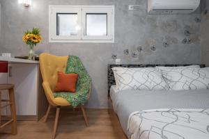 sypialnia z łóżkiem, krzesłem i biurkiem w obiekcie Cozy tiny apartment in the heart of Plaka w Atenach