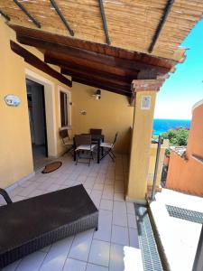 a patio with a table and chairs and the ocean at Bilocale Acquamarina presso i nidi dei cormorani in Costa Rei