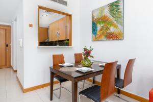 a dining room with a wooden table and chairs at Vacay Lettings - 1 Bed at Iris Blue, Dubai Marina in Dubai