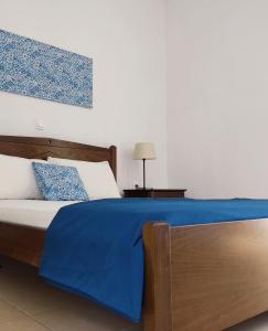 a bedroom with a bed with a blue blanket on it at Ενοικιαζόμενα Διαμερίσματα Άρτεμις in Skiros