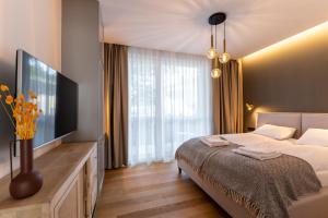 sypialnia z łóżkiem i telewizorem z płaskim ekranem w obiekcie WILANESKA Apartament Olimpijska Szczyrk w Szczyrku