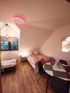1 dormitorio con 1 cama y 1 mesa con sillas en Apartament Luna, en Zamość