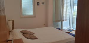 a bedroom with a bed with two brown pillows on it at Pende in Banjol