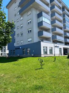 a large apartment building with a green lawn in front of it at City Break Arena Zagreb in Zagreb