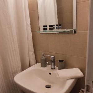 y baño con lavabo y espejo. en Ενοικιαζόμενα Διαμερίσματα Άρτεμις en Skyros