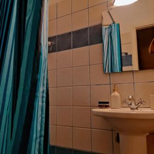 bagno con lavandino e doccia di Ενοικιαζόμενα Διαμερίσματα Άρτεμις a Skiros