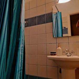 y baño con lavabo y ducha. en Ενοικιαζόμενα Διαμερίσματα Άρτεμις en Skyros