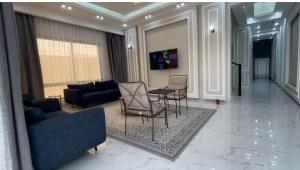 ein Wohnzimmer mit einem Sofa, einem Tisch und Stühlen in der Unterkunft Al Jabal Resort Villa 5 in Salalah