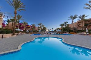 a swimming pool at a resort with palm trees at BLUE Lagoon View Resort & Spa in Marsa Alam City