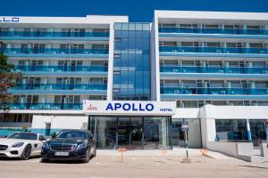 Hotel Apollo في نيبتون: سيارتين متوقفتين في موقف للسيارات امام مبنى