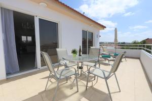 d'une terrasse avec une table et des chaises sur un balcon. dans l'établissement Nissi 3 Amazing Sea View Apartment, à Ayia Napa