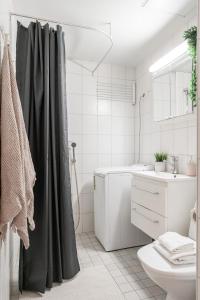 a bathroom with a shower curtain and a sink at 2ndhomes Tampere "Pieni Verka" Apartment - Superior Downtown Apt Near Restaurants in Tampere