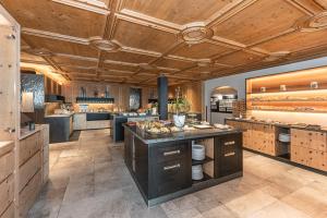 duża kuchnia z drewnianymi sufitami i dużą wyspą w obiekcie DAS GERSTL Alpine Retreat w mieście Malles Venosta