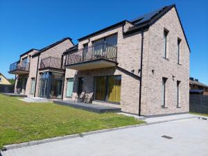 una gran casa de ladrillo con césped delante en SALIA KOPU 2, en Klaipėda 69 fotos más