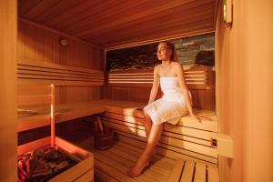 a woman is sitting in a sauna at Villa Bellevue Portoroz-Portorose in Portorož