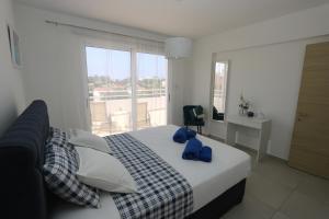 a bedroom with a bed with blue towels on it at Nissi 3 Amazing Sea View Apartment in Ayia Napa