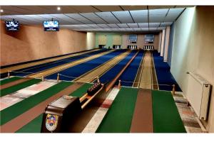 a bowling alley with lanes and televisions at Heide Hotel Reinstorf in Reinstorf