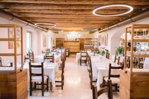 a dining room with white tables and chairs at BACCO D'ORO Wine & Relais in Mezzane di Sotto