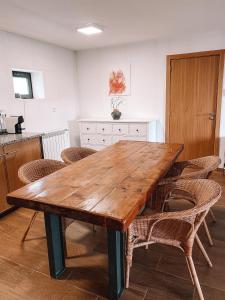 a large wooden table in a kitchen with chairs at Oficina do Joe , Bungalow Gitte in Outeiro