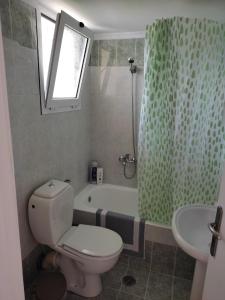 a bathroom with a toilet and a tub and a sink at ARETI4 in Petalidi +23 photos