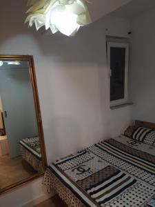een slaapkamer met 2 bedden en een spiegel bij Lovely 1 bedroom apartment near Eye of Tirana in Tirana