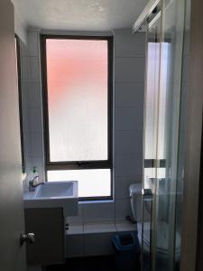 a bathroom with a window and a sink and a toilet at Departamento Viña del Mar in Viña del Mar