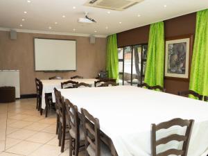 a conference room with tables and chairs and a screen at Slot Loevenstein Guest House in Dan Pienaar