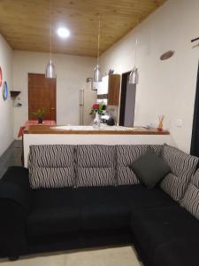 czarna kanapa w salonie z kuchnią w obiekcie Casa Aconchegante na Roça - Roseli w mieście São Francisco Xavier