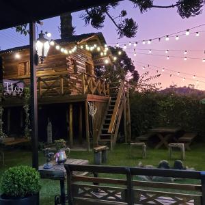 une cabane dans les arbres avec un panier de basket et des lumières dans l'établissement Tico Pousada, à Campos do Jordão