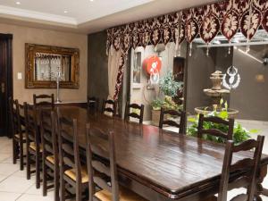 uma sala de jantar com uma grande mesa de madeira e cadeiras em Slot Loevenstein Guest House em Dan Pienaar