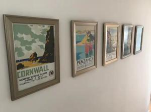 a group of framed posters on a wall at A woodland retreat - Apartment in converted mill in Helston