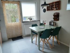 een keuken met een tafel en stoelen en een raam bij 't KISTJE Bed by the Sea in Koudekerke