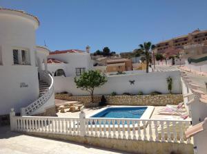 a villa with a swimming pool and a white fence at Casa di Paddy in Ciudad Quesada