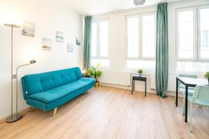 a living room with a blue couch and a table at Charming Central Cityflats in Antwerp