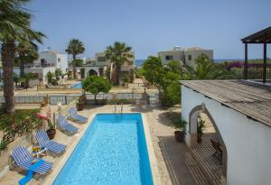 een uitzicht over een zwembad met stoelen en een resort bij Villa Euphoria in Protaras
