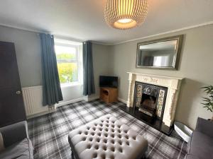 a living room with a couch and a fireplace at Pass the Keys Spacious 3BR Cottage in Beautiful Rural Setting in Castle Douglas