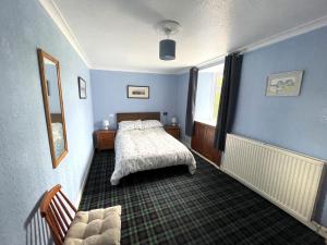 una camera blu con un letto e un divano di Pass the Keys Spacious 3BR Cottage in Beautiful Rural Setting a Castle Douglas