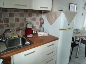 a kitchen with a sink and a white refrigerator at Syros House with View in Ermoupoli