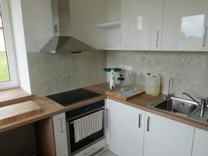 a kitchen with white cabinets and a sink at Penzion Renesance in Drnovice