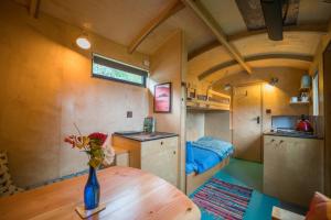 ein kleines Zimmer mit einem Tisch in einem winzigen Haus in der Unterkunft Empress En Suite Wagon in Arthog