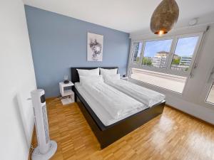 um quarto com uma cama grande e uma janela grande em ARISER - Zug Central Business Apartment em Zug