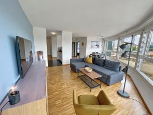 a living room with a couch and a table and chairs at ARISER - Zug Central Business Apartment in Zug
